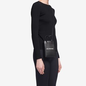 Woman Balenciaga shopping phone holder.